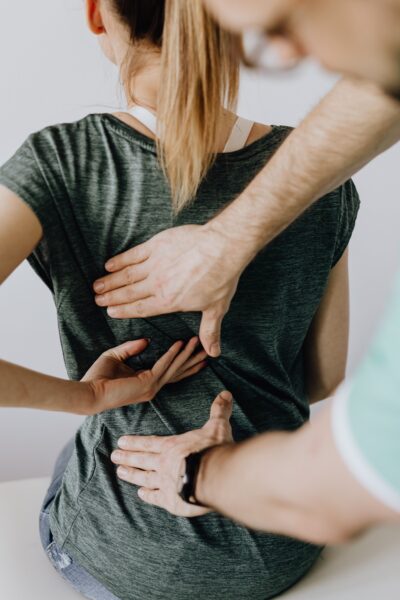Chiropractor explaining why not to wait until you hurt to receive preventative chiropractic adjustments